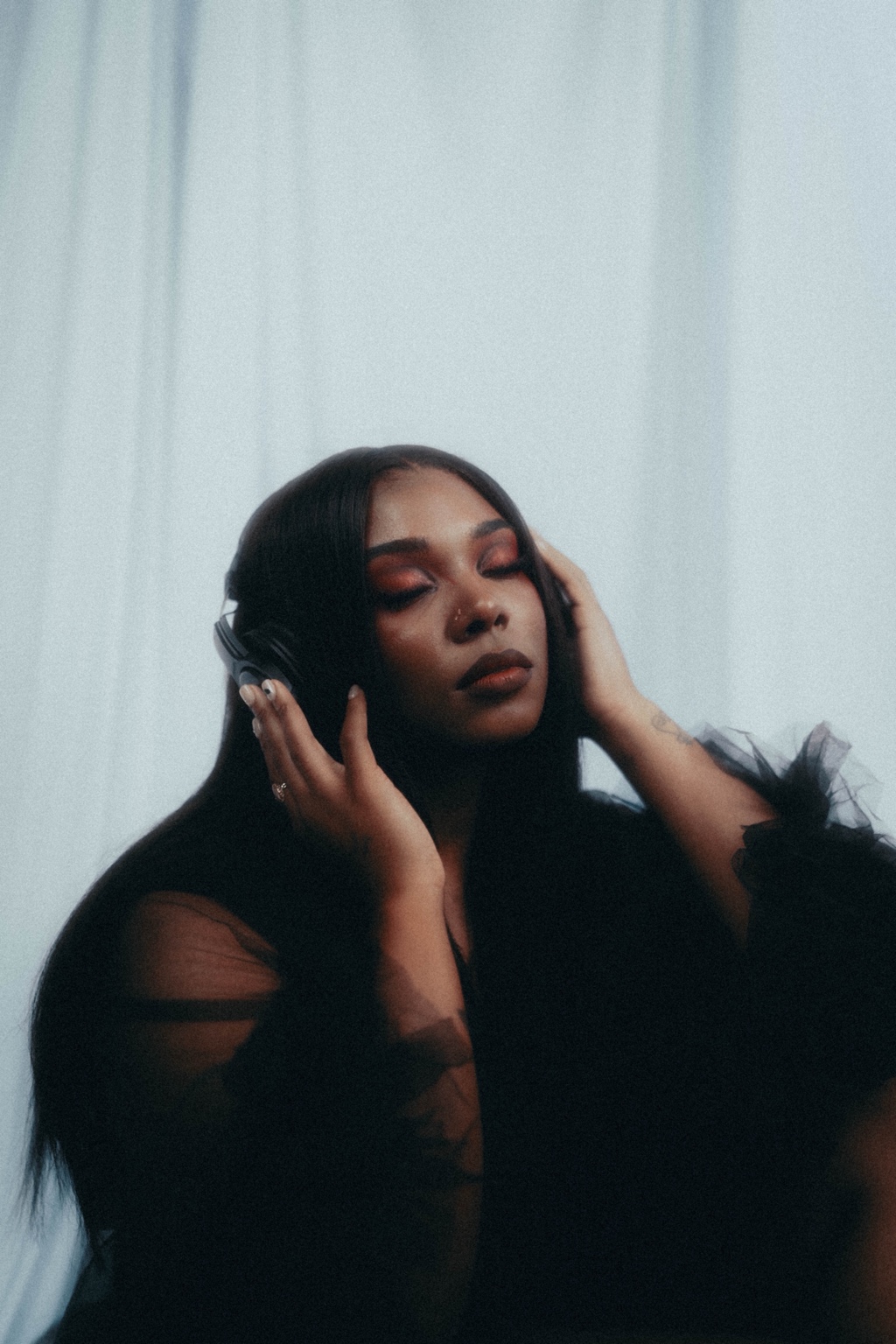 Sierra Von listening through over-ear headphones